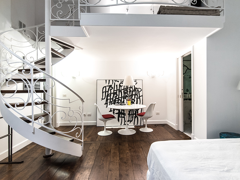 Camera da letto soppalcata con scala a chiocciola artigianale