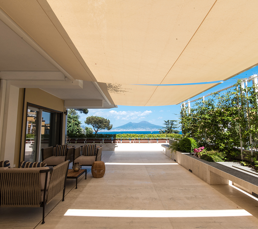 Terrazza esterna a livello con pavimento in Travertino Navona e panche in Peperino